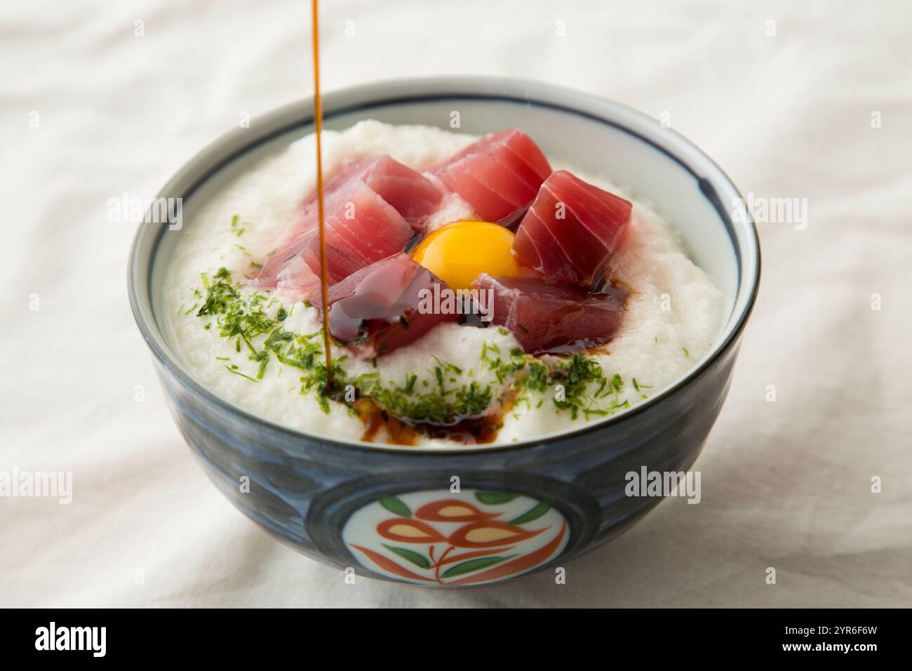 Thunfisch-Yamakake-Donburi mit Wachtelei darauf, garniert mit Sojasauce Stockfoto