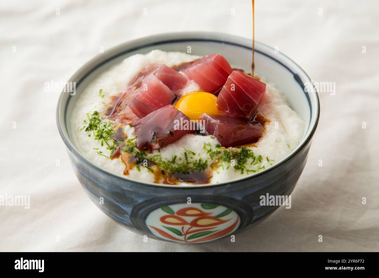 Thunfisch-Yamakake-Donburi mit Wachtelei darauf, garniert mit Sojasauce Stockfoto