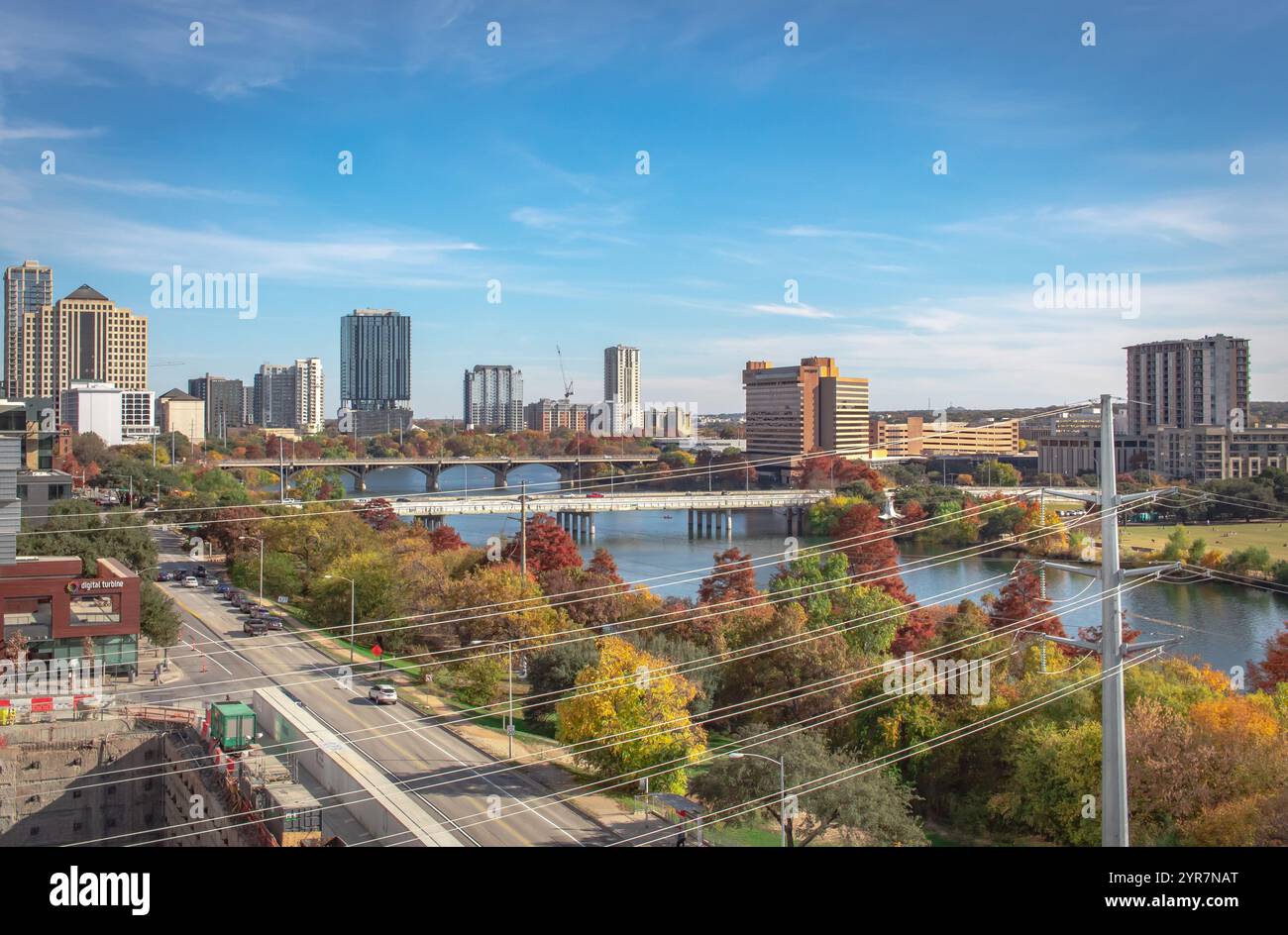 Blick auf die Gebäude von Austin Texas entlang des Lady Bird Lake, umgeben von bunten Herbstbäumen und Stromleitungen. Foto gemacht im Austin Texas City Public Li Stockfoto