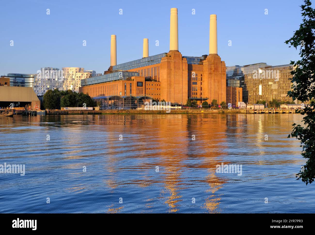 Restauriertes Battersea Power Station leuchtend orange kurz nach Sonnenaufgang und Reflexionen in der Themse, London, England, Großbritannien Stockfoto