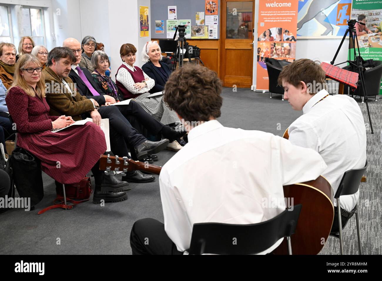 Der erste Minister John Swinney hört die Gitarre von Flynn Conroy und Oscar Phillips von der James Gillespie High School während einer Zeremonie, nachdem Peter Mackay als neuer Makar (National Poet for Scotland) bekannt gegeben wurde. Die Position von Makar besteht darin, Arbeiten zu bedeutenden nationalen Veranstaltungen zu produzieren und eine Führungsrolle bei der Förderung der Poesie auf nationaler Ebene zu übernehmen. Bilddatum: Montag, 2. Dezember 2024. Stockfoto