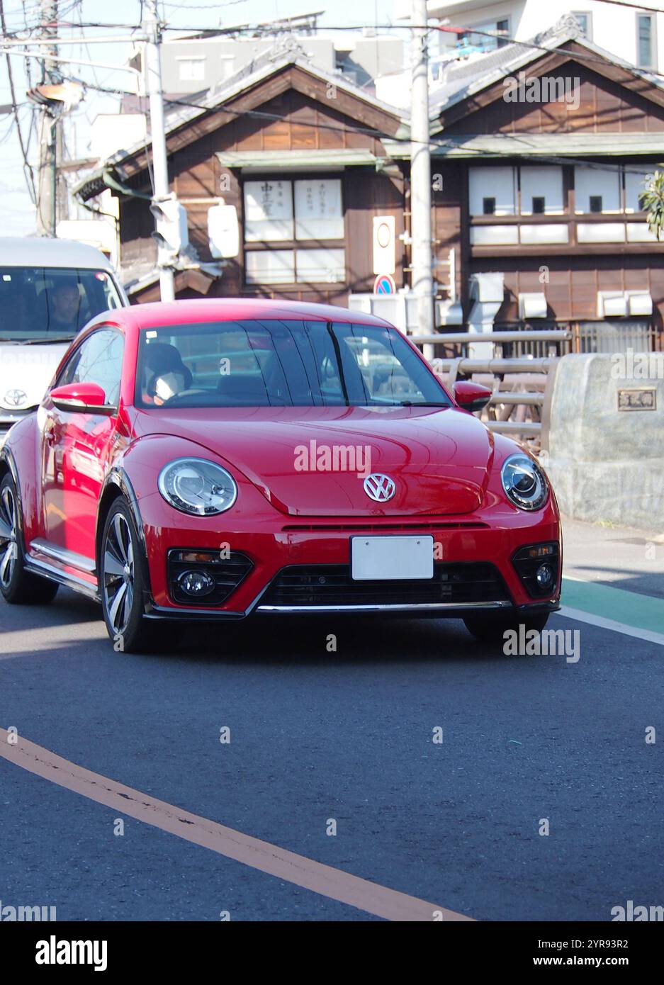 Ein roter, deutscher Volkswagen New Beetle fährt auf den Straßen der Stadt Stockfoto