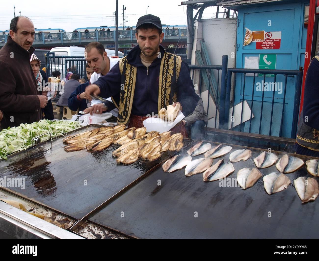 Türkischer Mann verkauft frittierten Fisch an Touristen in Eminonu in Istanbul. Essen auf der Straße ist ein Teil des lokalen Lebens hier. Stockfoto