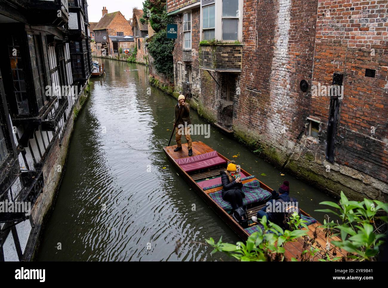 Touristen machen eine historische Bootstour auf dem Fluss Stour durch Canterbury. Der Great Stour könnte behaupten, Englands historischster Fluss zu sein. In römischer und mittelalterlicher Zeit war der Fluss eine wichtige Verkehrsroute, die Canterbury mit dem europäischen Festland verband. Die Stadt gehört zum UNESCO-Weltkulturerbe in der Grafschaft Kent, England, war bis 1974 County Borough und liegt am Fluss Stour. Canterbury ist eine Stadt und UNESCO-Weltkulturerbe in der Grafschaft Kent, England; es war bis 1974 County Borough. Er liegt am Fluss Stour. Stockfoto