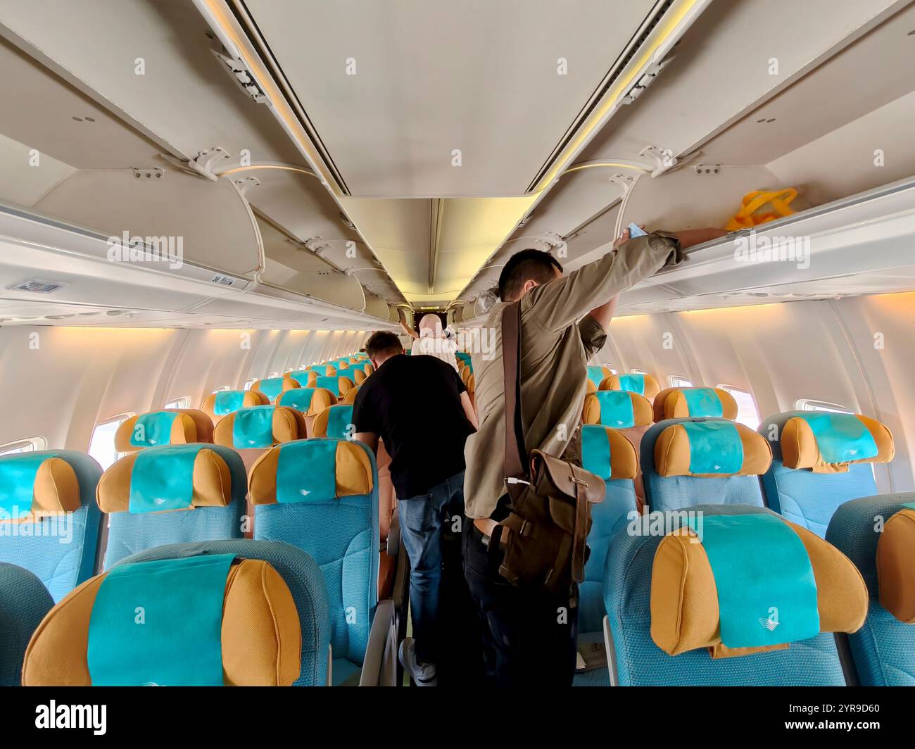 Bali, Indonesien - 23. November 2024: Passagier eines Handelsflugzeugs legten ihr Gepäck in die Kabine, bevor sie am Flughafen Ngurah Rai, Bali, in starteten Stockfoto