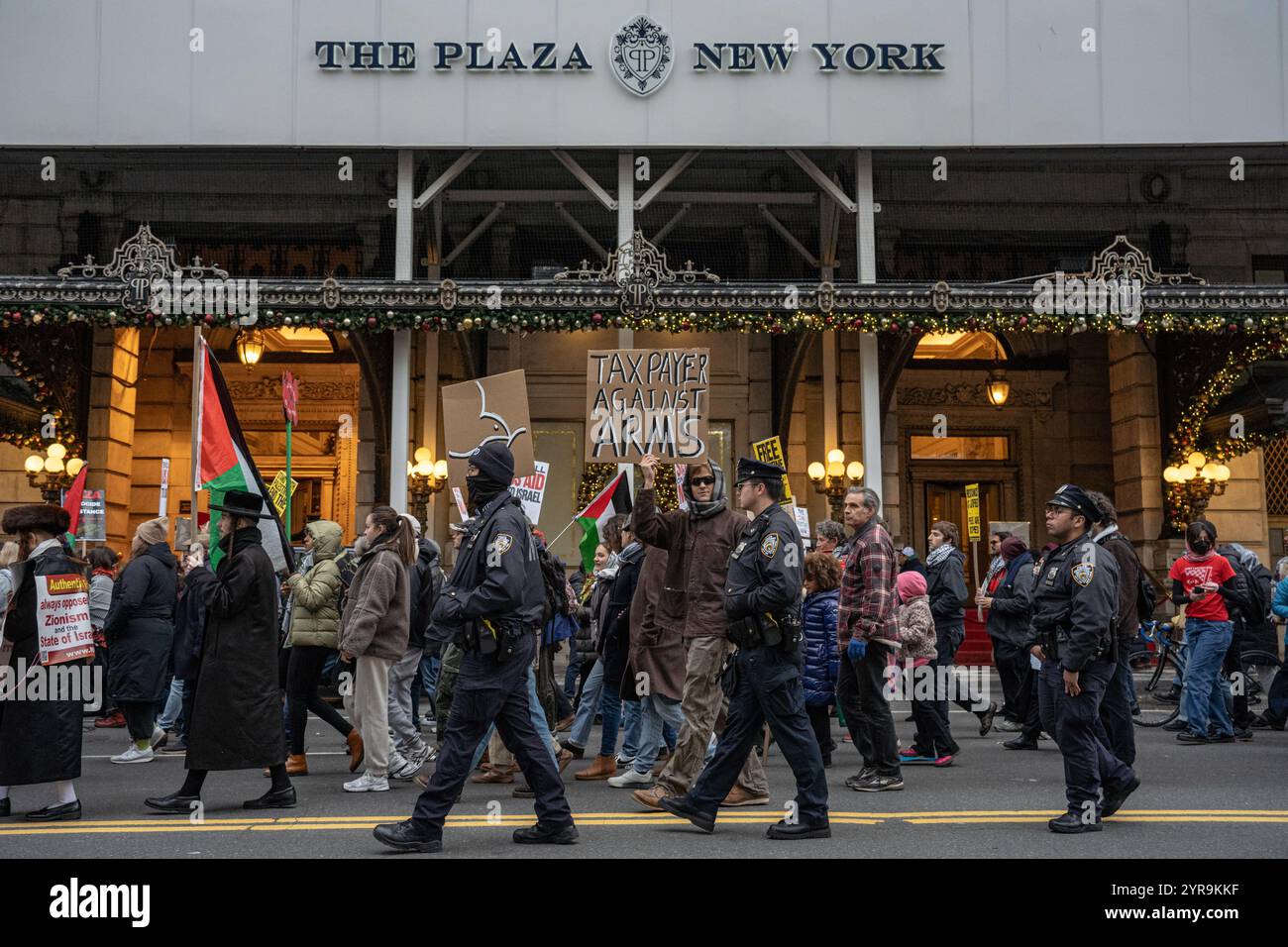 Manhattan, Usa. November 2024. Ein Mann hält vor dem Plaza Hotel ein Schild mit der Aufschrift "Tax Payer Against Arms". Hunderte pro-palästinensischer Demonstranten versammeln sich am Columbus Circle zum "Internationalen Tag der Solidarität für das palästinensische Volk" in New York City. (Foto: Derek French/SOPA Images/SIPA USA) Credit: SIPA USA/Alamy Live News Stockfoto