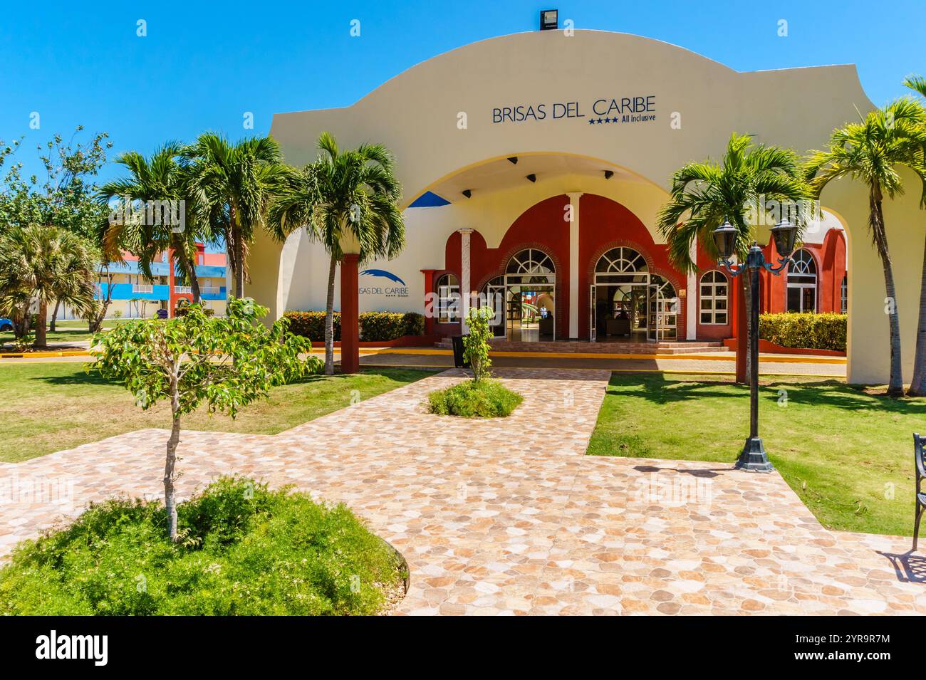 Ein großes Gebäude mit einem roten Dach und einer weißen Fassade. Das Gebäude hat einen großen Torbogen und ein großes Schild mit der Aufschrift „Dias del Carre“. Stockfoto