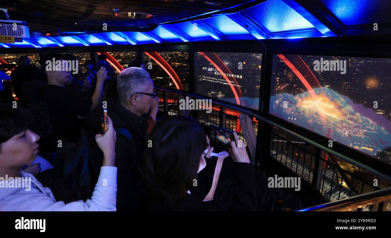 Some images are projected onto a translucent sheet along with the actual night view at Kyoto Tower in Shimogyo Ward, Kyoto City, Kyoto Prefecture on December 3, 2024. The projection mapping in the observation deck displays popular Kyoto spots such as Kiyomizu-dera Temple and Fushimi Inari-taisha Shrine, as well as beautiful illustrations of Kyoto's four seasons.( The Yomiuri Shimbun via AP Images ) Stockfoto