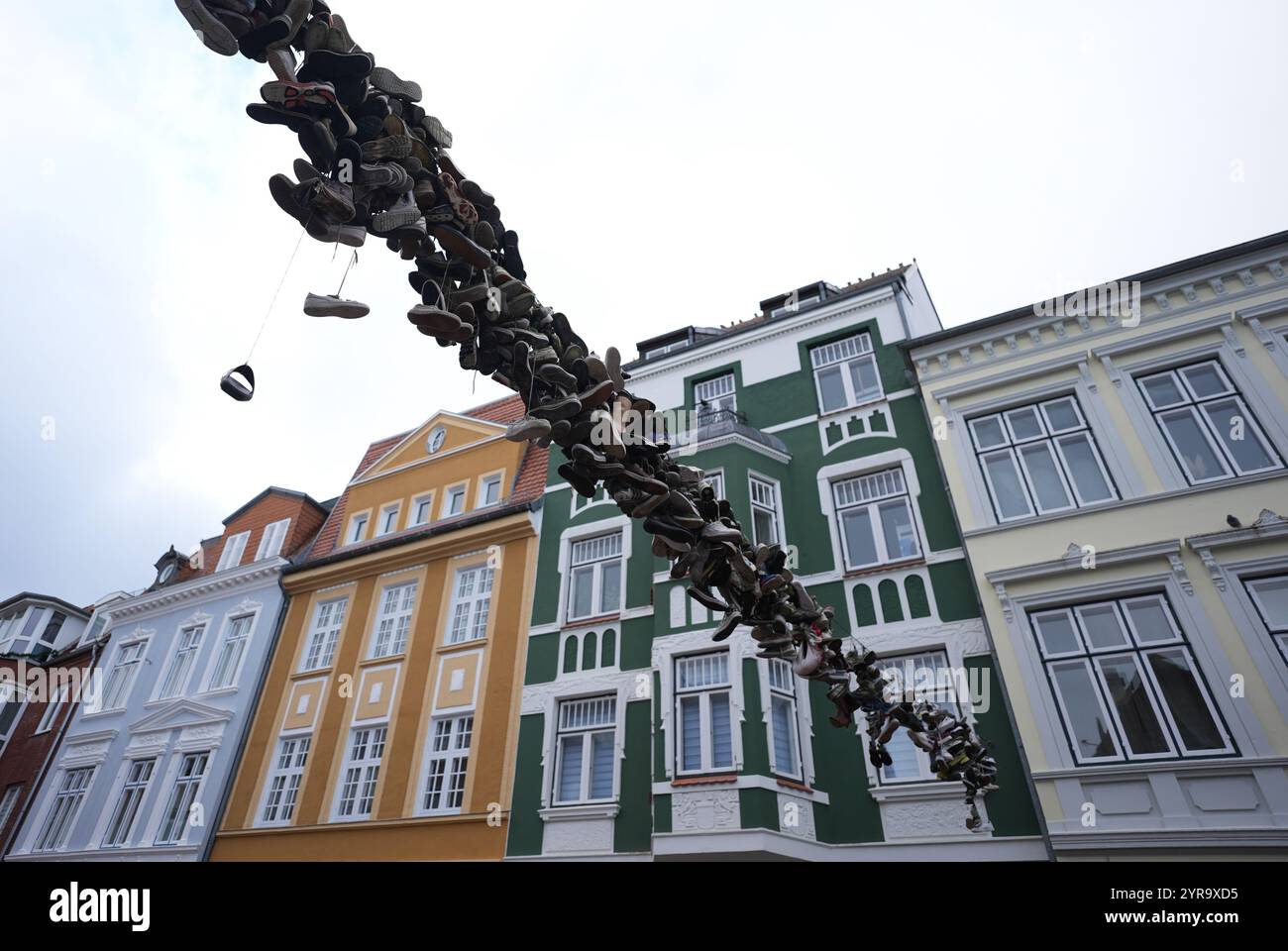 Flensburg, Deutschland. Dezember 2024. Schuhe hängen an einem Drahtseil oberhalb der Norderstraße. Quelle: Marcus Brandt/dpa/Alamy Live News Stockfoto