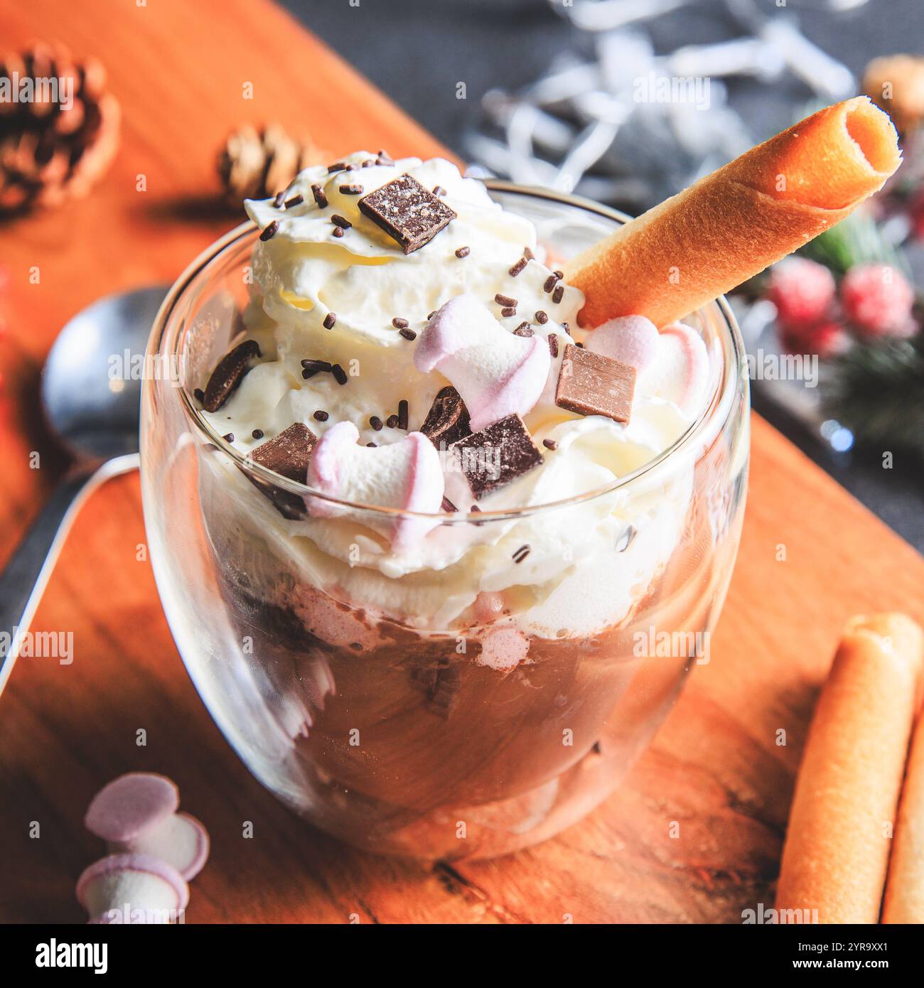 Traditionelle heiße Schokolade mit Schlagsahne, Marshmallows und Schokoladenspänen in einer Weihnachtsdekoration im Studio Stockfoto
