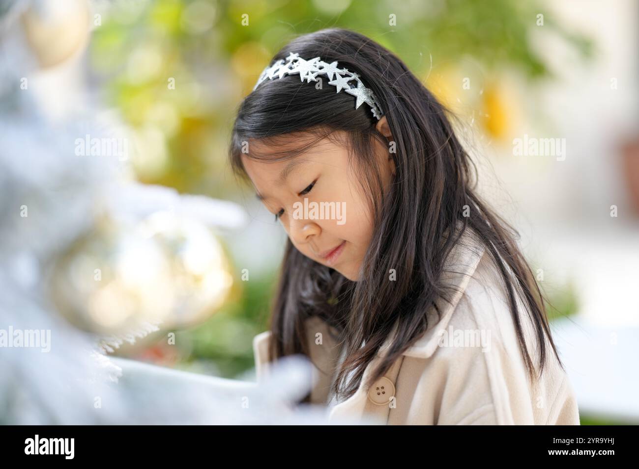 Eine 9-jährige Singapurin schmückt den Weihnachtsbaum in einem schönen Weihnachtscafé in der Innenstadt von Shanghai, China. Stockfoto Eine 9-jährige Singapurin schmückt den Weihnachtsbaum in einem schönen Weihnachtscafé in der Innenstadt von Shanghai, China. Stockfoto
