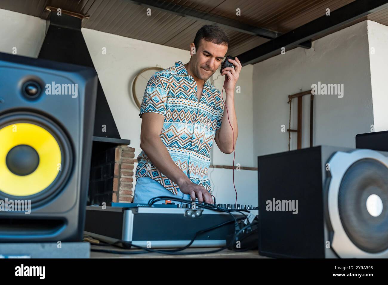 Ein elektrisierender DJ lockt die Menge mit lebhaften Beats auf, die die Atmosphäre einer spanischen Party entfachen und die Fans begeistern. Stockfoto