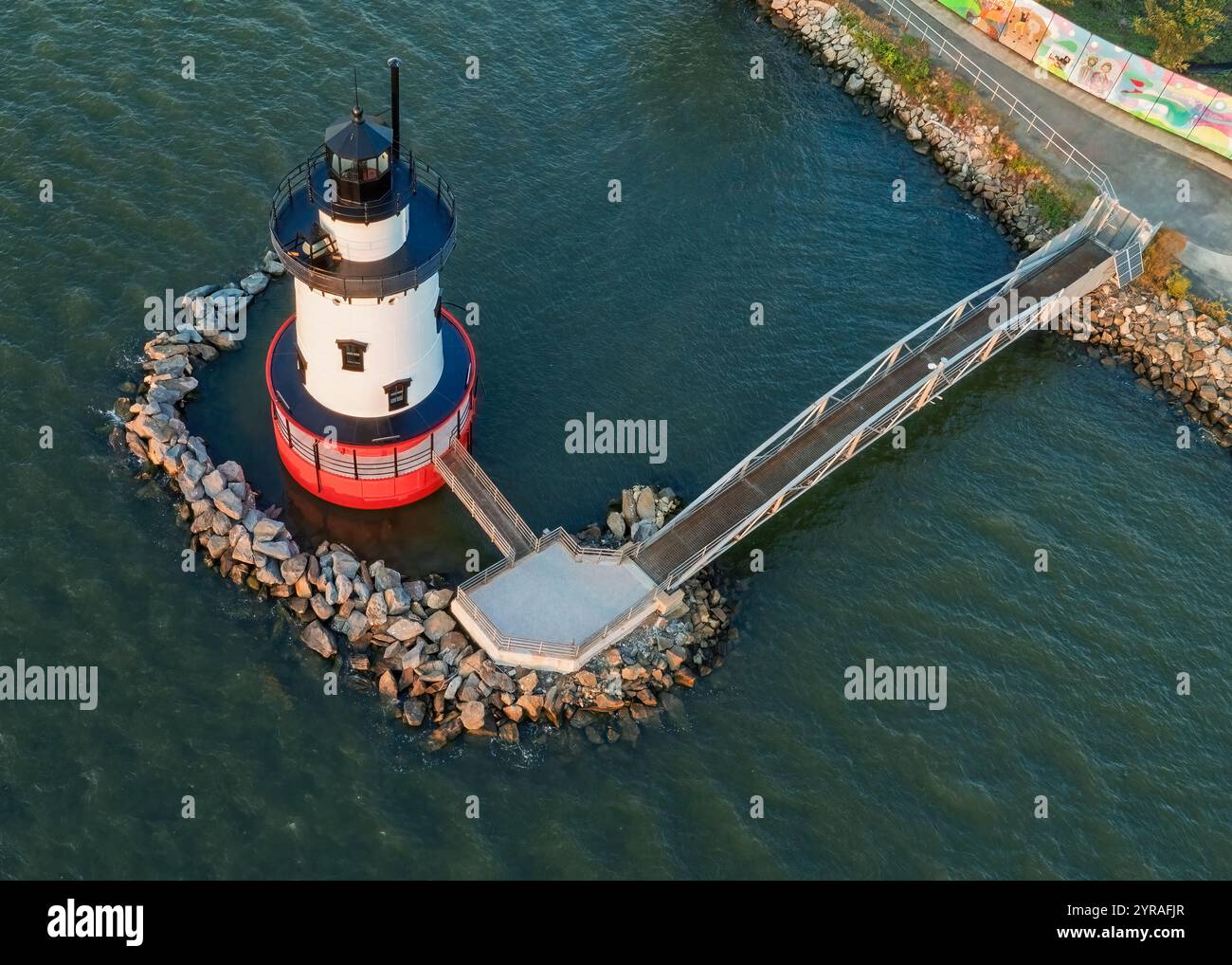 Luftaufnahme des rot-weißen Leuchtturms in Tarrytown, New York. Der Leuchtturm ist von Felsen umgeben, die mit einem Fußweg zum Ufer verbunden sind. Th Stockfoto