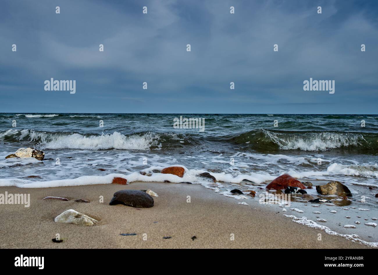 Wunderschöner Panoramablick auf die Ostsee vom Sandstrand mit einigen bunten Felsen und ansprechenden Wasserwellen (Schönhagen, Deutschland) Stockfoto