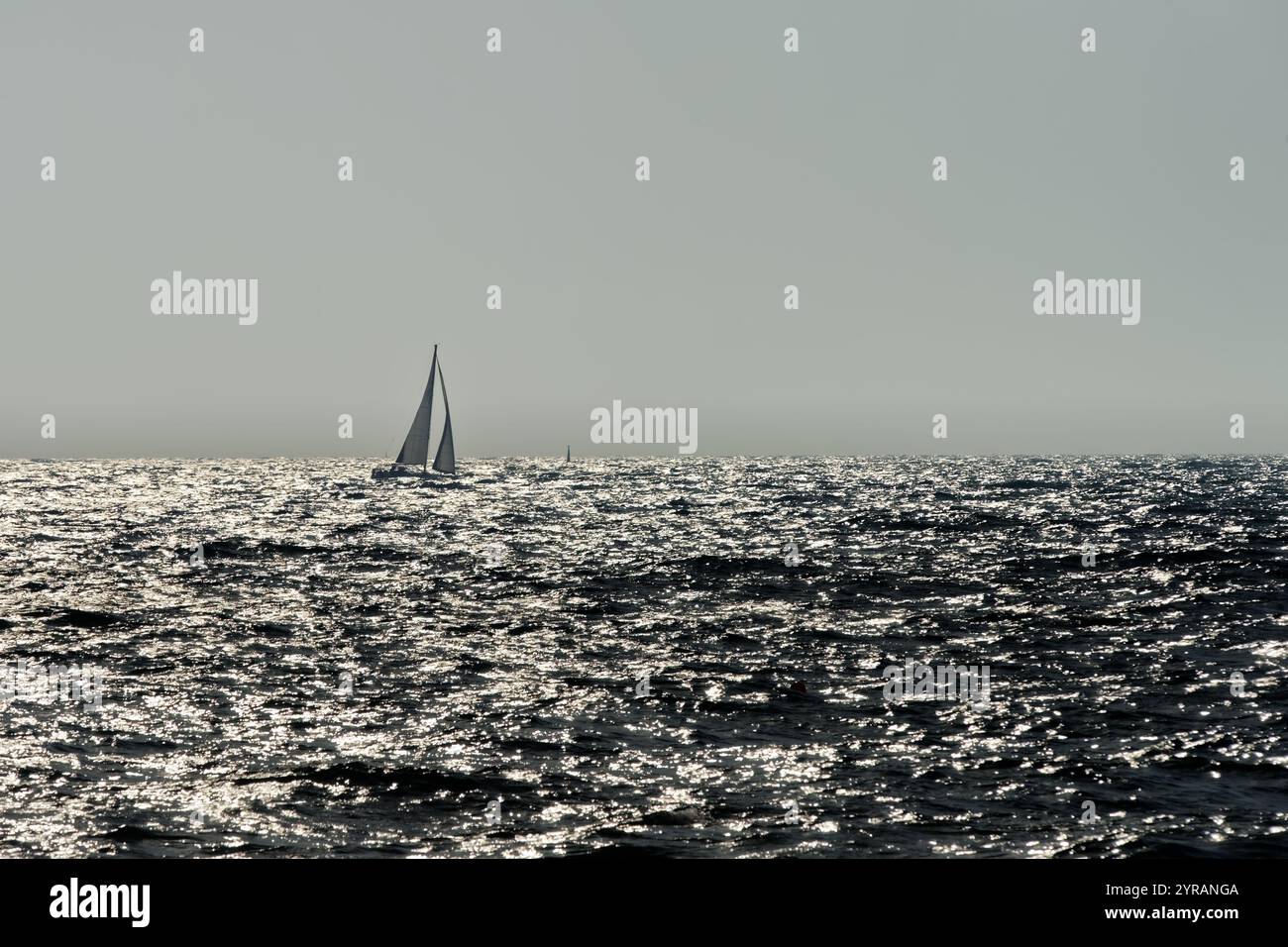 Kleines Segelboot auf den glitzernden Wellen der Ostsee Stockfoto