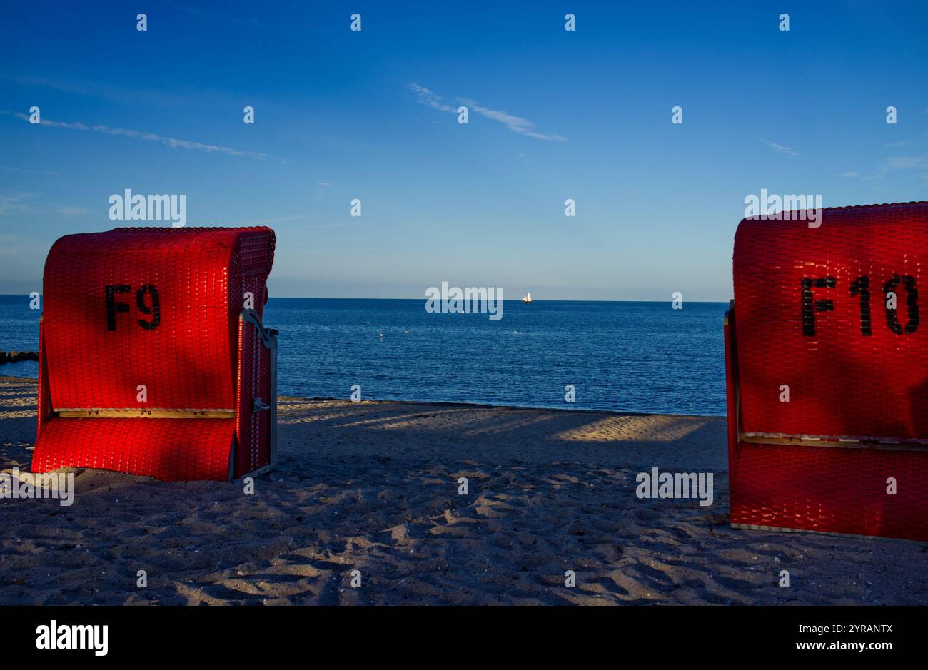 Blick auf die Ostsee durch rote gedeckte Korbstühle am Sandstrand von Schönhagen, Kieler Bucht, Schleswig-Holstein, Deutschland Stockfoto