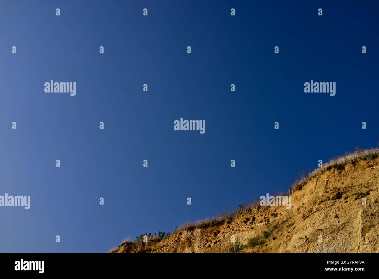 Klarer blauer Himmel und in der unteren rechten Ecke ein Abschnitt der Steilküste mit Kalksandsteinklippen bei Schönhagen, Ostsee, Deutschland Stockfoto