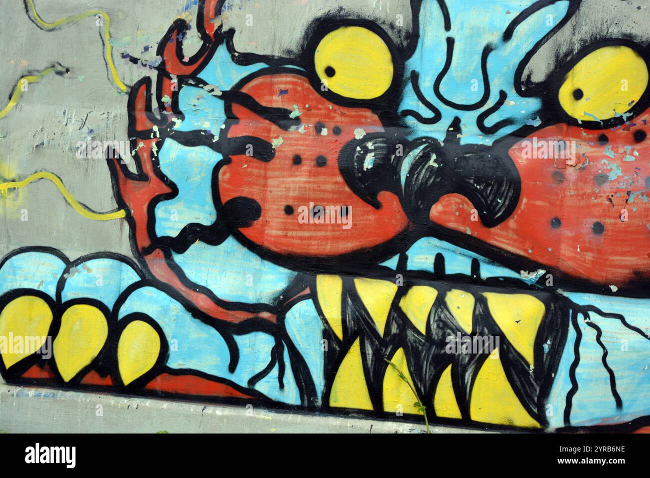 Wunderschöne, lebendige Zeichnungen und Tierbilder auf einer bräunlich-grauen Betonwand. Graffiti, ein großer Kopf, die Mündung eines Tigers mit Blau, Grau. Stockfoto