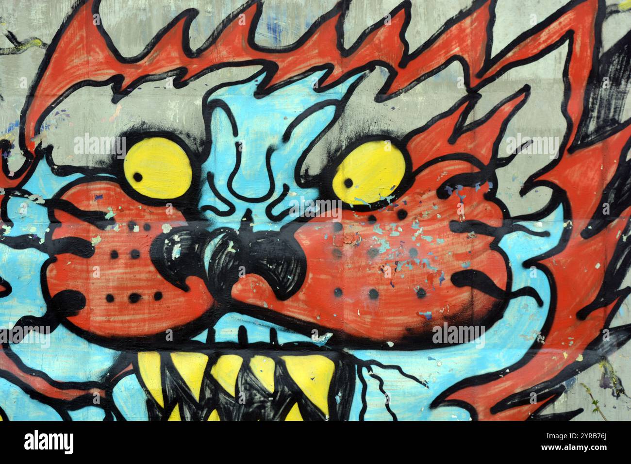 Wunderschöne, lebendige Zeichnungen und Tierbilder auf einer bräunlich-grauen Betonwand. Graffiti, ein großer Kopf, die Mündung eines Tigers mit Blau, Grau. Stockfoto