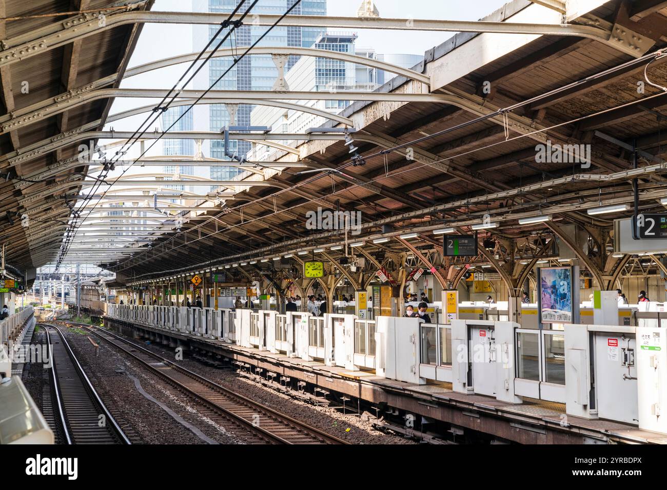 Sehen Sie entlang des Bahnsteigs eins der Yoyogi-Station in Tokio auf der Yamanote-Linie. Er ist mit den neuesten automatischen Barrieren ausgestattet. Ein paar Leute warten. Stockfoto