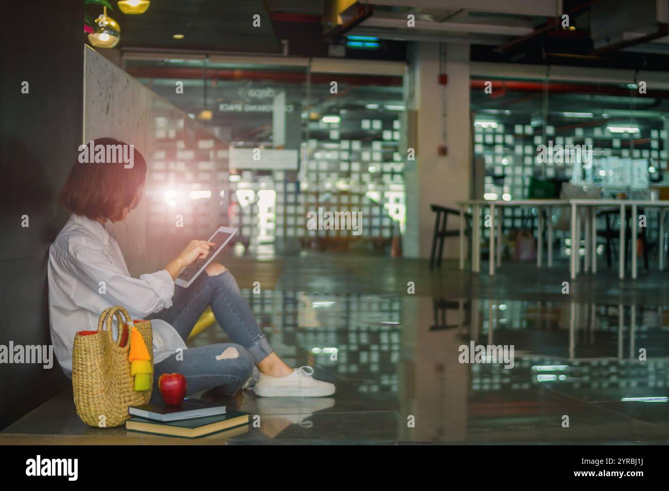 Die junge Frau nutzt ein Tablet in der Hand, um im Internet nach Informationen zu suchen und lernt, wie sie mit dem Tablet die Suche nach dem erleichtert Stockfoto