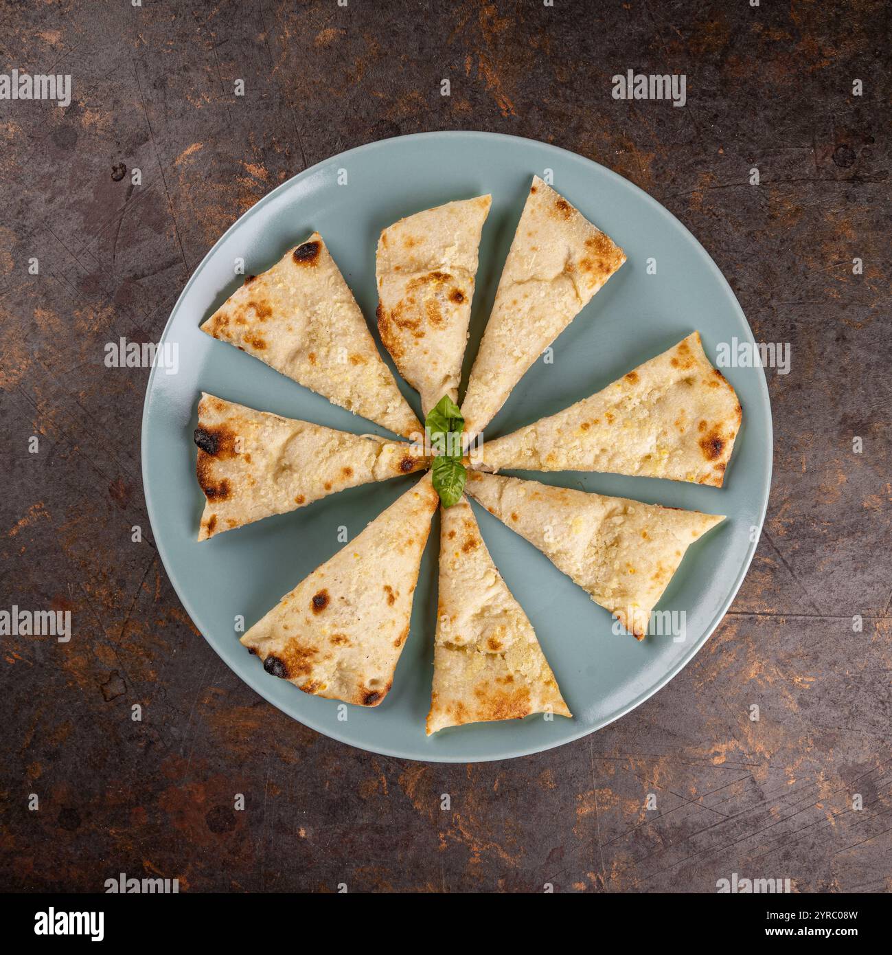Naan-Brotscheiben im Kreis auf einer blauen Platte, Stockfoto