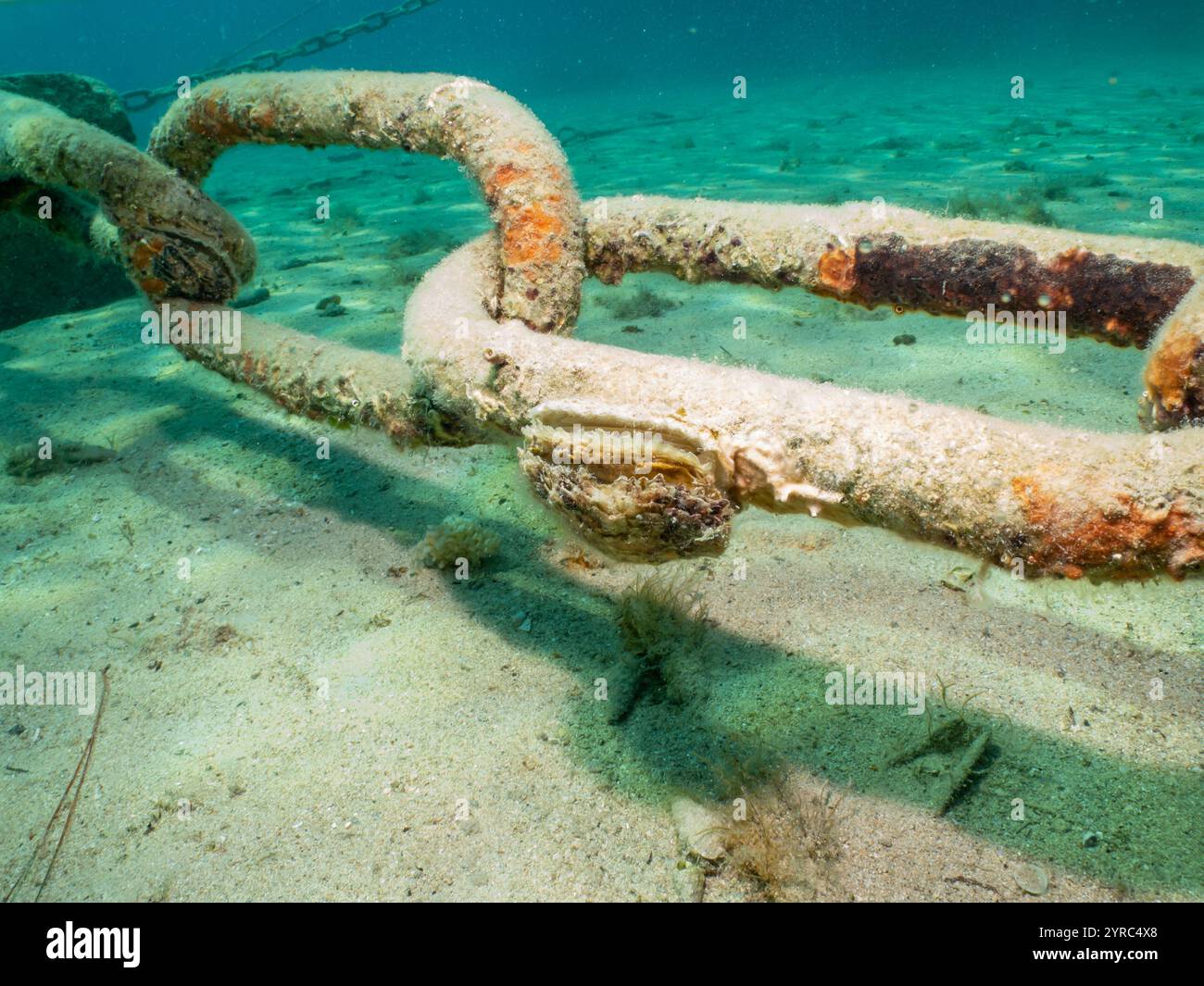 Ankerkette am Grund der Adria bei Losinj, Kroatien. Sand und türkisfarbenes Wasser im Hintergrund Stockfoto