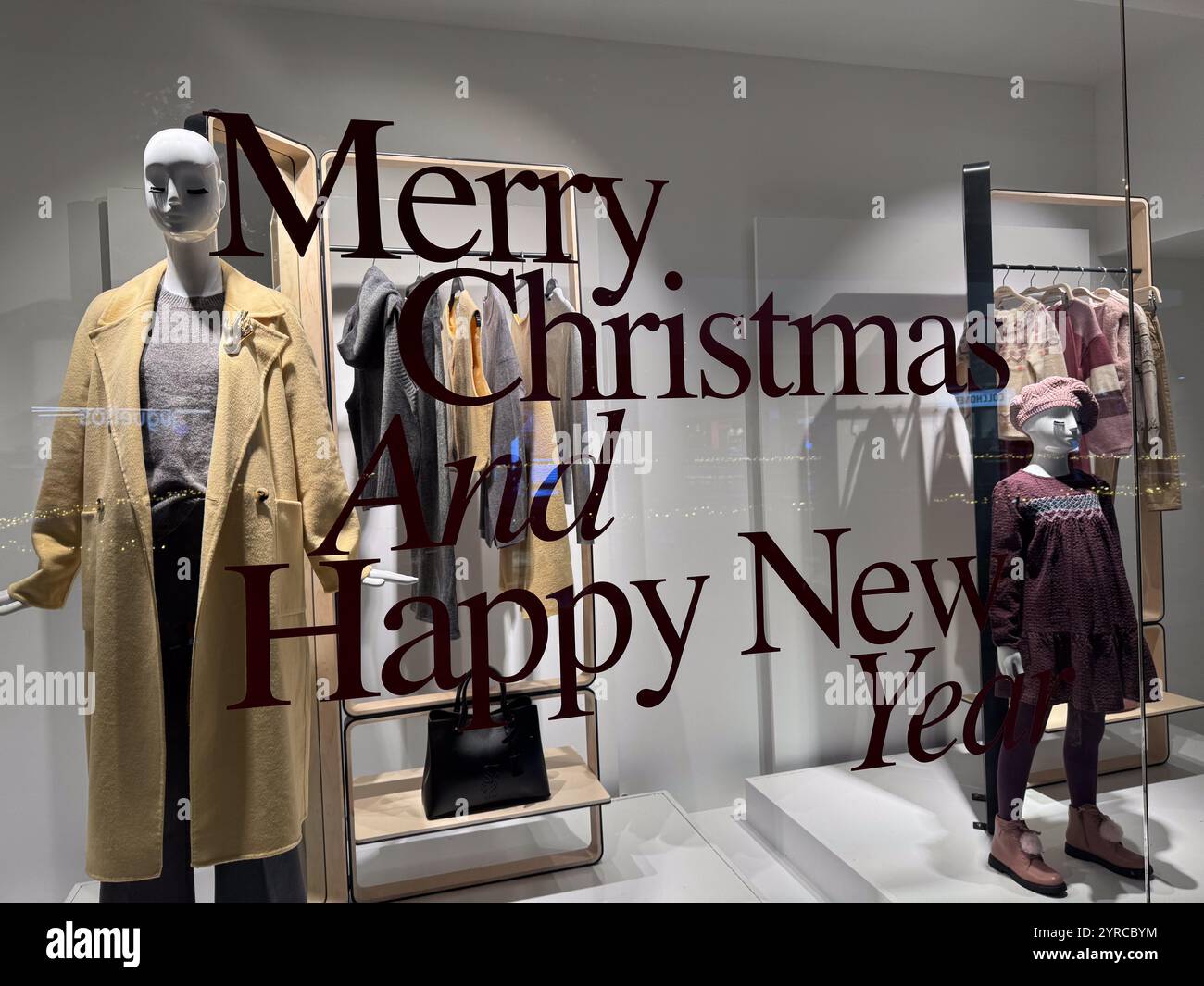 Frohe Weihnachten und Happy New Year Schild am Fenster eines Bekleidungsgeschäfts Stockfoto