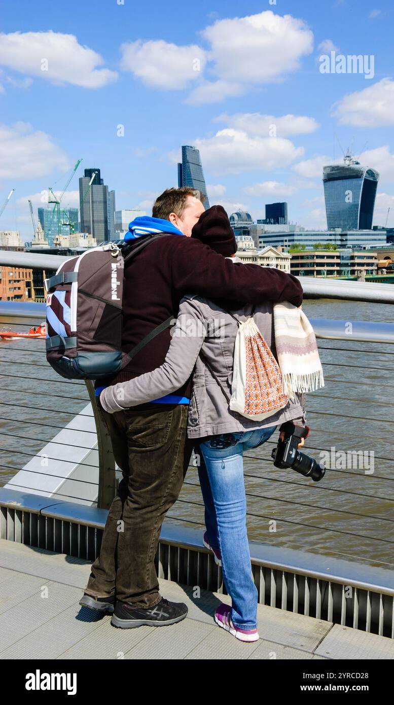 LONDON, ENGLAND, Großbritannien - 3. MAI 2014: Nicht identifizierte Touristen schauen von der Millennium Bridge aus auf das Stadtbild. Millennium Bridge, die Bankside wi verbindet Stockfoto