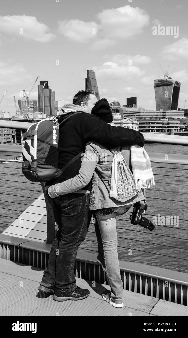 LONDON, ENGLAND, Großbritannien - 3. MAI 2014: Nicht identifizierte Touristen schauen von der Millennium Bridge aus auf das Stadtbild. Schwarzweißes historisches Foto. Stockfoto