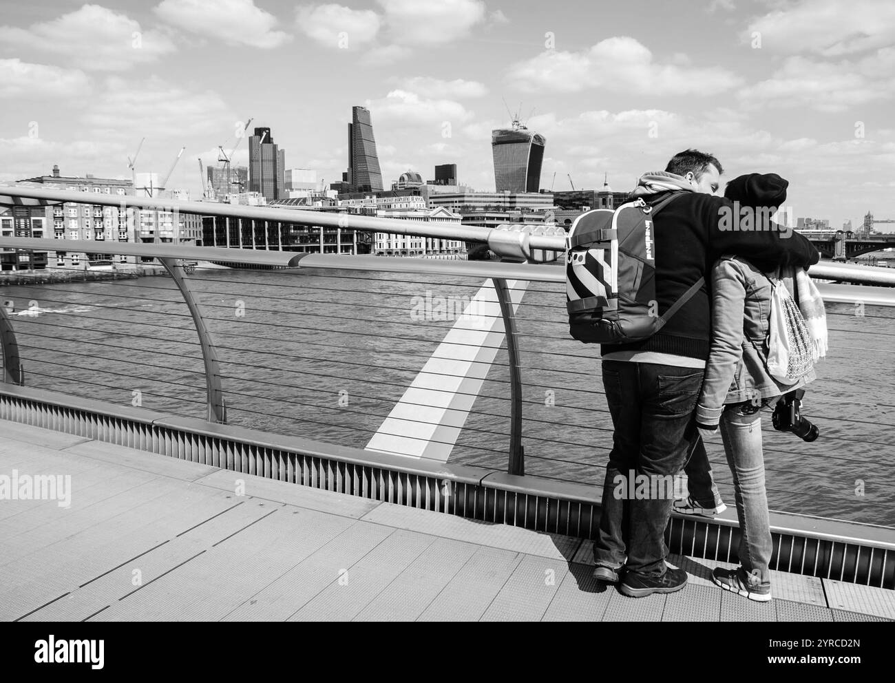 LONDON, ENGLAND, Großbritannien - 3. MAI 2014: Nicht identifizierte Touristen schauen von der Millennium Bridge aus auf das Stadtbild. Schwarzweißes historisches Foto. Stockfoto