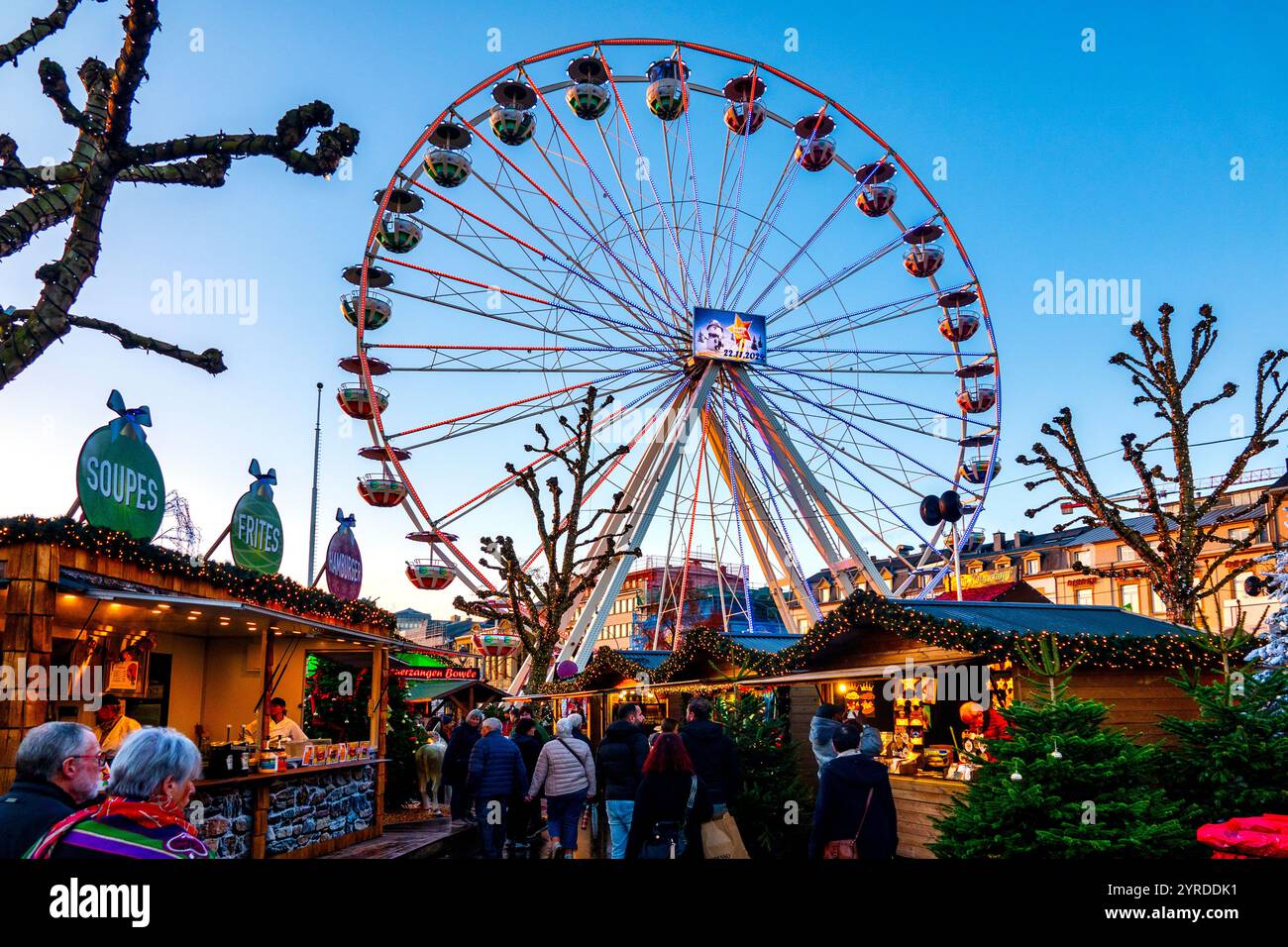 Das pulsierende Riesenrad am Wantermaart (Wintermarkt) in Luxemburg-Stadt, Luxemburg, umgeben von festlichen Ständen und Besuchern. Stockfoto