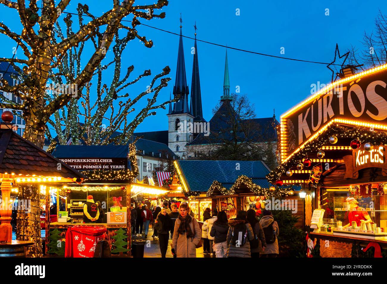 Festliche Stände am Wantermaart (Wintermarkt) in Luxemburg-Stadt, mit den Türmen der Kathedrale Notre-Dame im Hintergrund Stockfoto