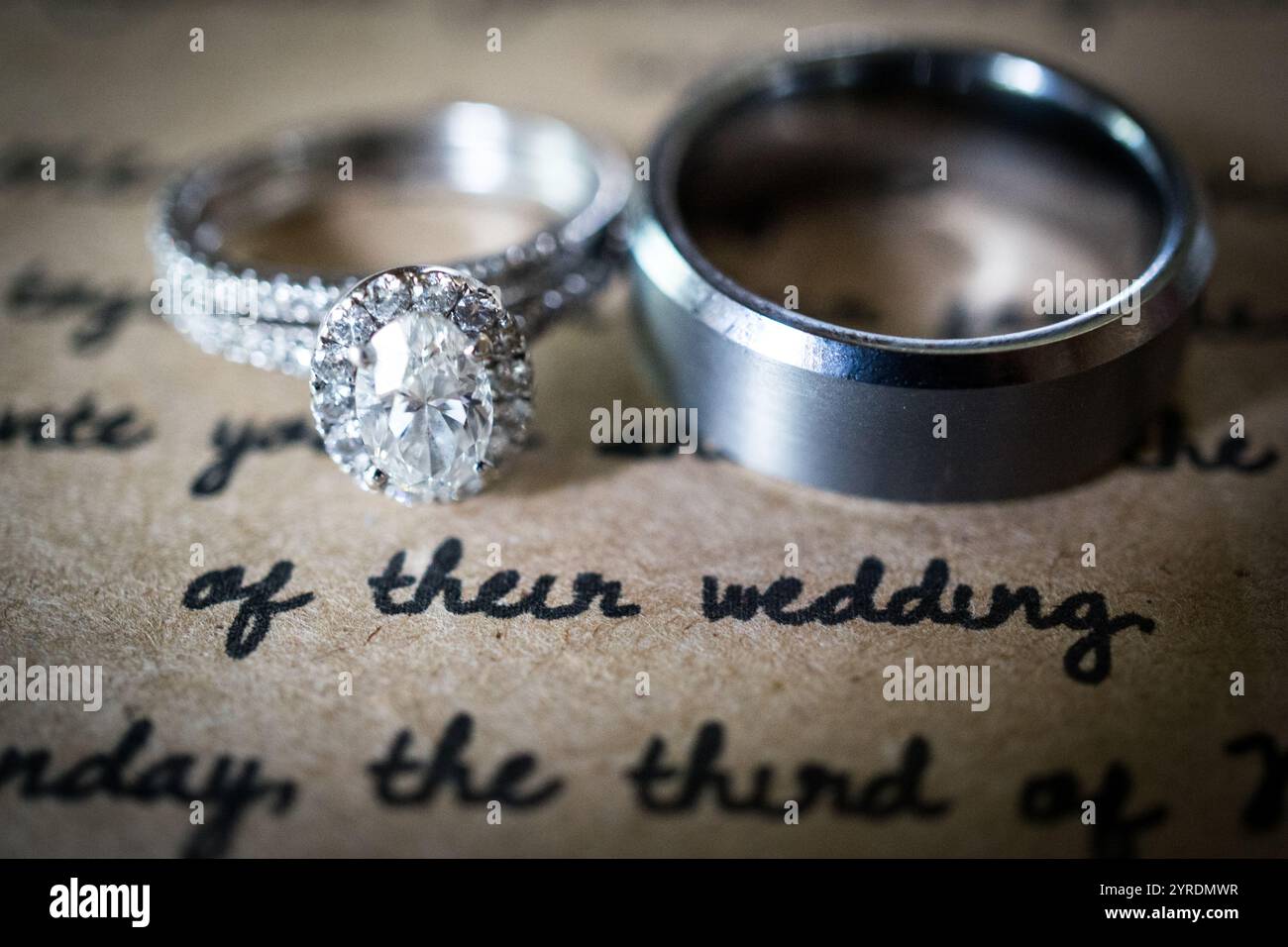 Elegante Hochzeitsringe auf Einladung Hintergrund mit weichem Fokus Stockfoto