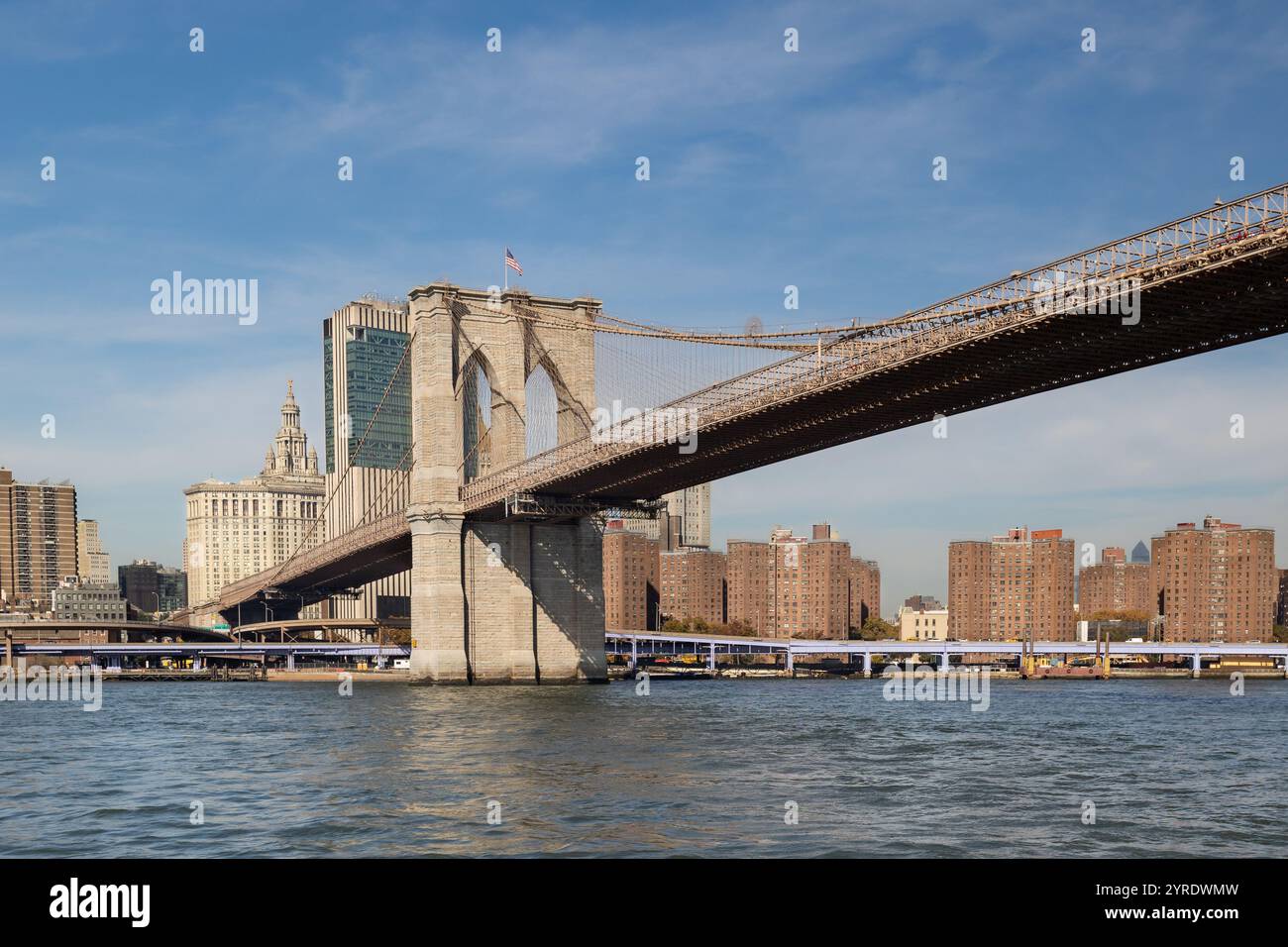 Die Brooklyn Bridge verbindet Manhattan und Brooklyn über den East River und zeigt ihre ikonische Architektur vor einem klaren blauen Himmel Stockfoto