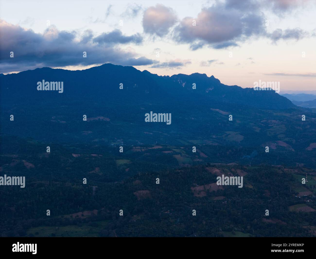 Goldene Sonnenuntergänge erleuchten die Bergkette und enthüllen grüne Täler und weit entfernte Gipfel in ruhiger Ruhe. Stockfoto