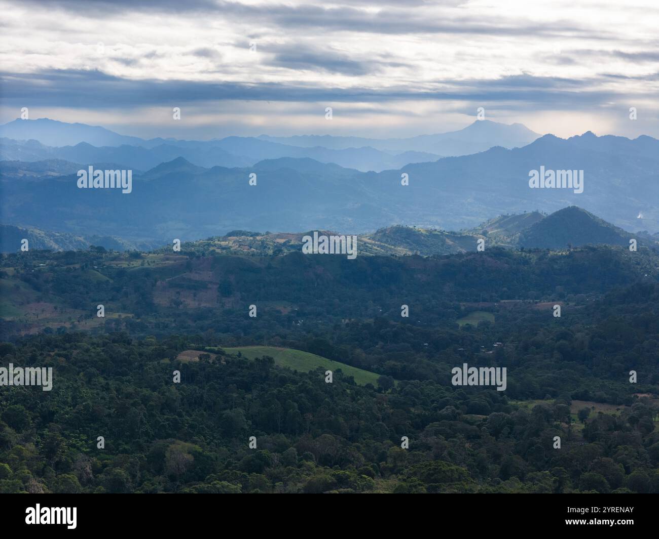 Riesige grüne Hügel und Berge verschmelzen sich unter bewölktem Himmel im frühen Morgenlicht zum Horizont und zeigen die Schönheit der Natur. Stockfoto