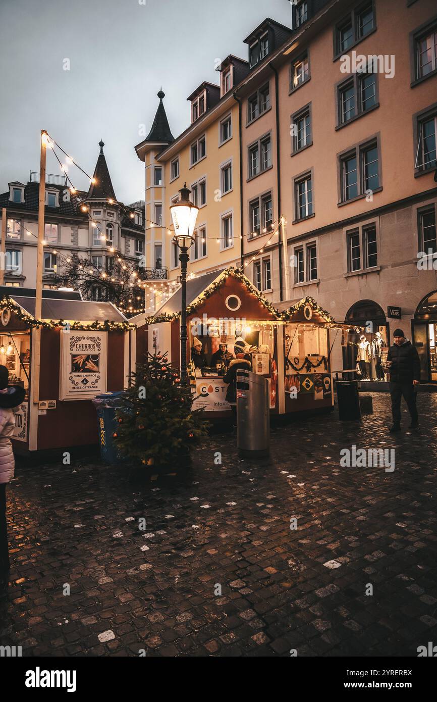 Eine lebendige Szene der Weihnachtsmärkte in Zürich mit festlicher Dekoration, Lichtern und belebten Straßen, die den Feiertagsgeist der Stadt einfangen. Stockfoto