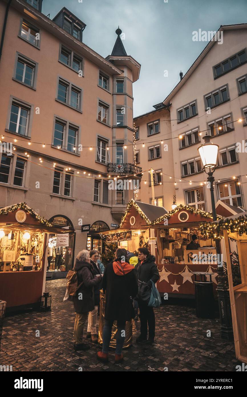 Eine lebendige Szene der Weihnachtsmärkte in Zürich mit festlicher Dekoration, Lichtern und belebten Straßen, die den Feiertagsgeist der Stadt einfangen. Stockfoto