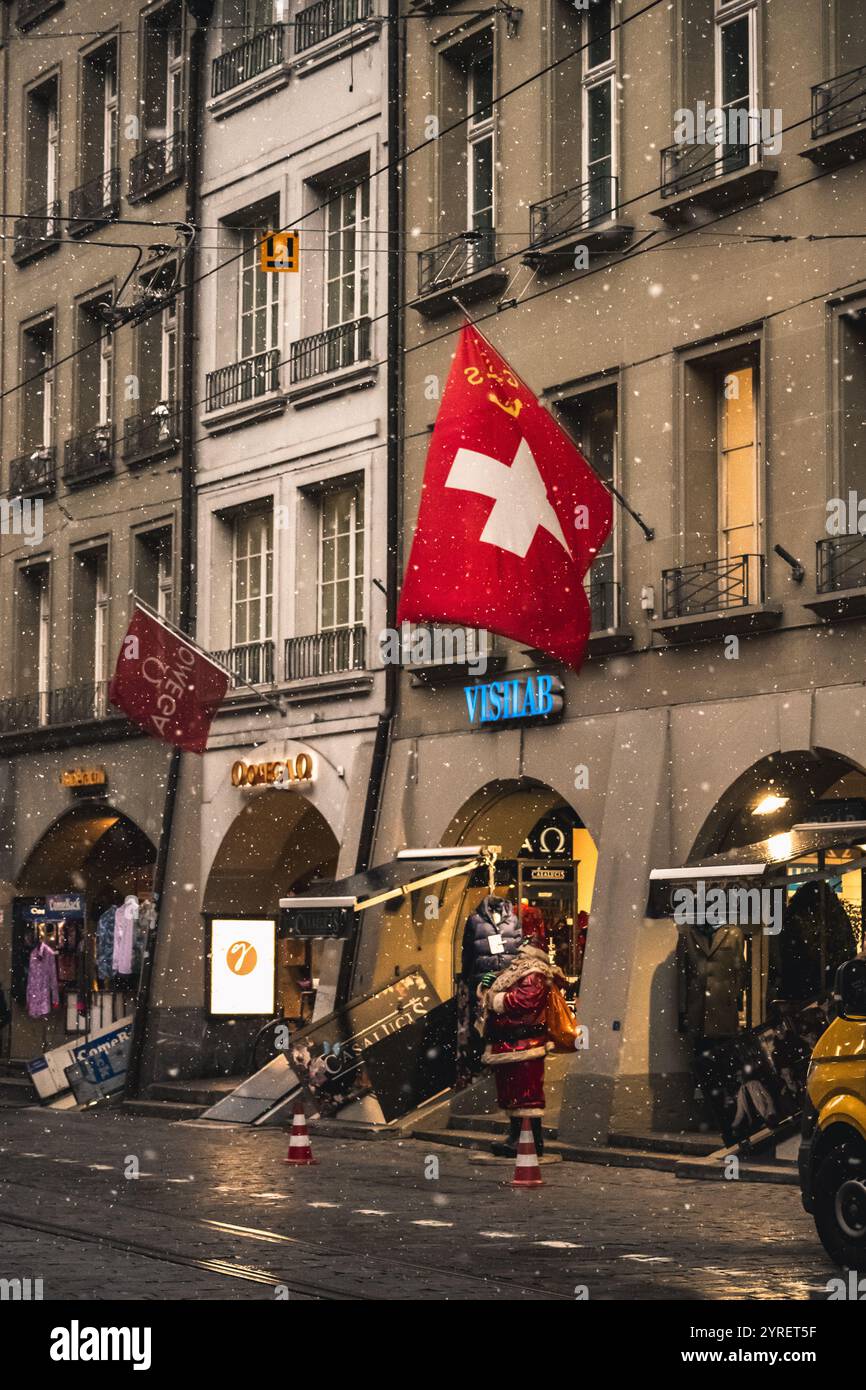 Ein malerischer Blick auf Berns Straßen und Straßenbahnen, die während Weihnachten mit Schnee bedeckt sind, und fängt den festlichen Charme und das winterliche Ambiente ein. Stockfoto