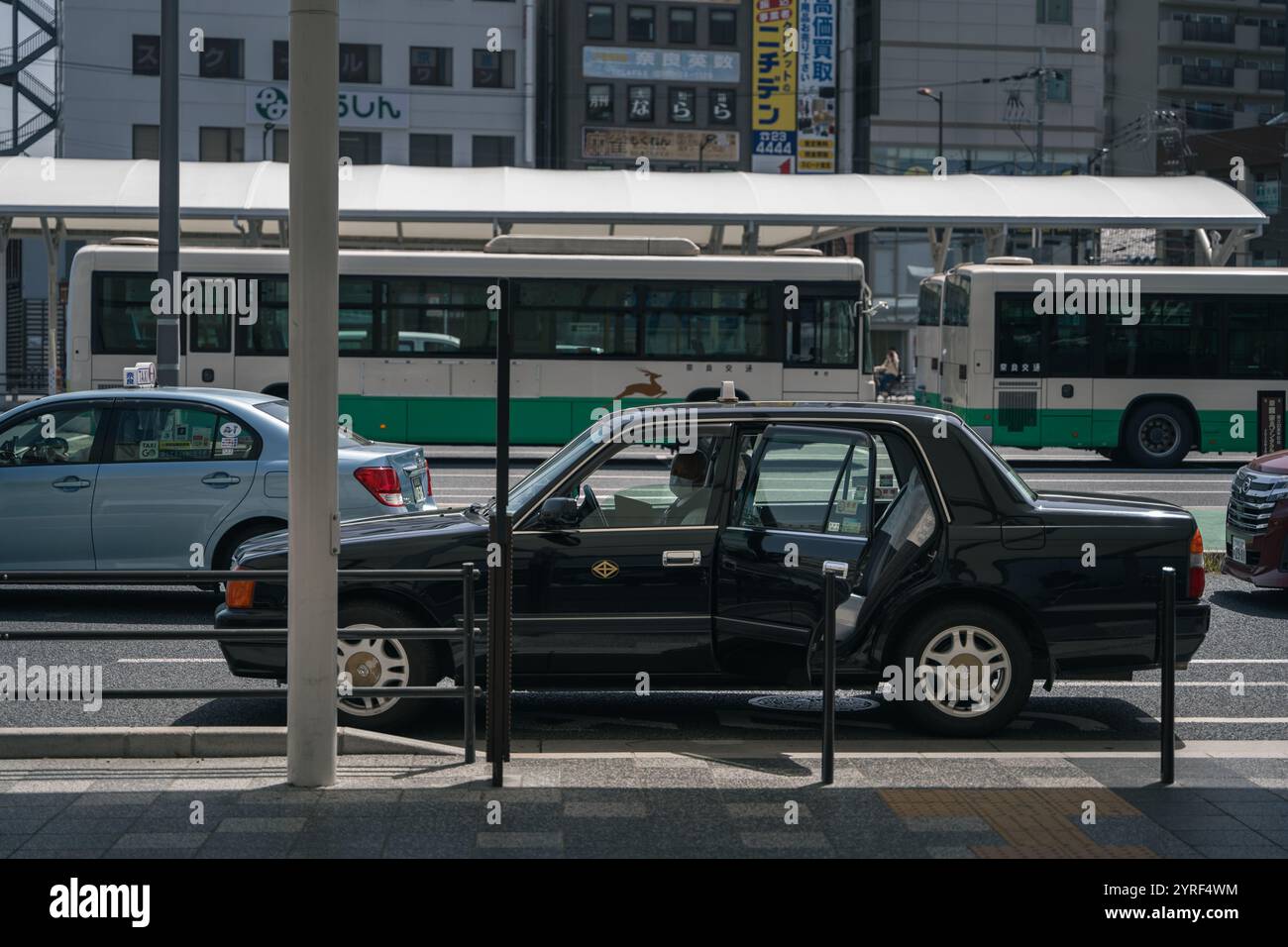 Ein geparktes Taxi wartet an einem Bahnhof in Japan und hält einen ruhigen Moment im städtischen Nahverkehr und im Alltag fest. Stockfoto