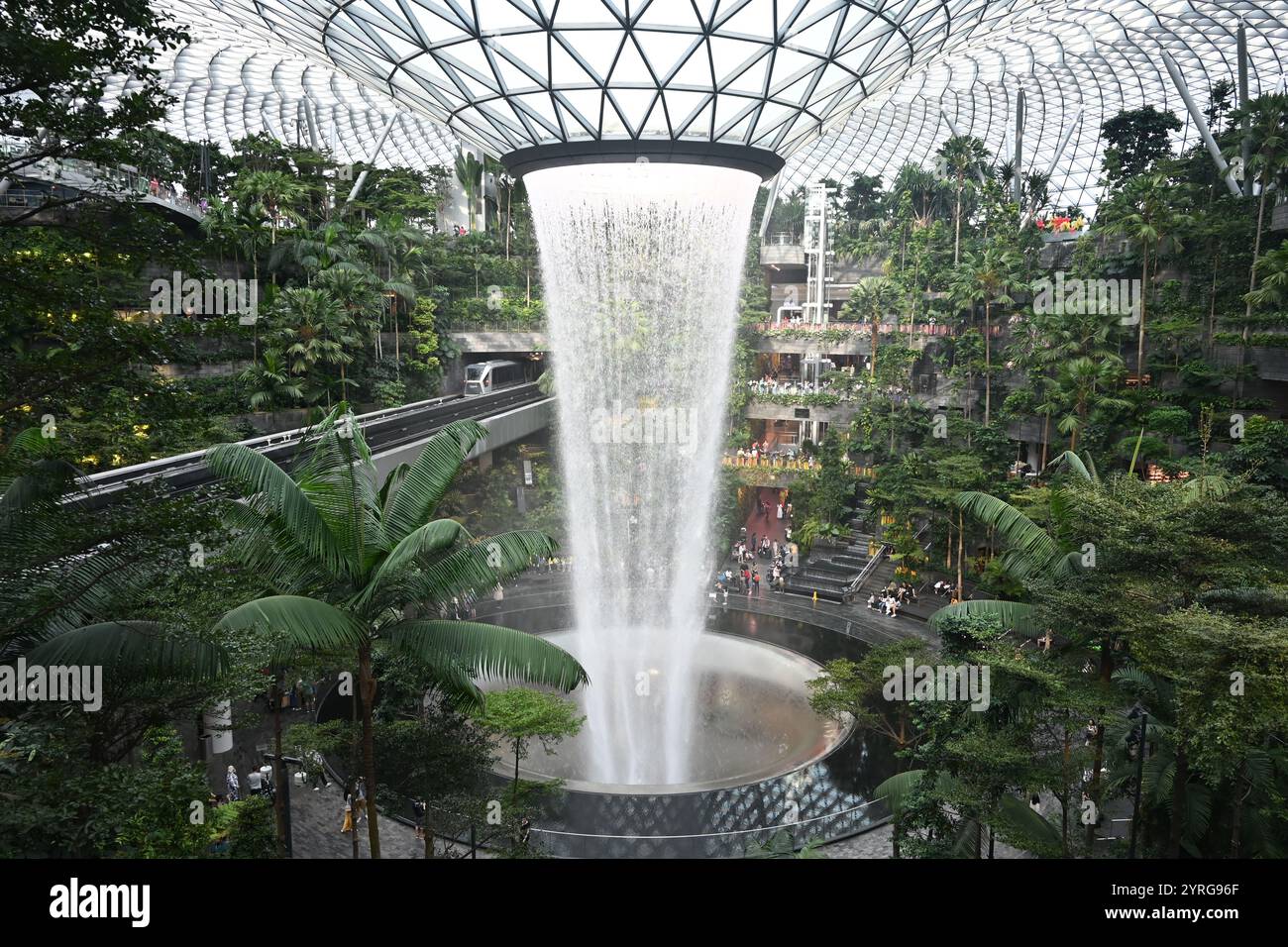 Indoor-Wasserfall inmitten üppiger tropischer Gärten mit Skylight am Flughafen Singapur Changi Stockfoto