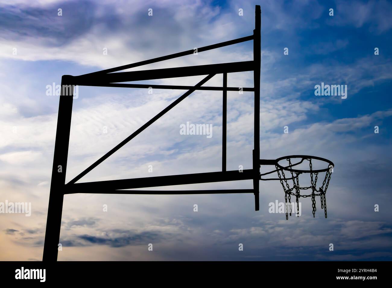 Basketballkorb mit Kettennetz und dramatischem Himmel Stockfoto