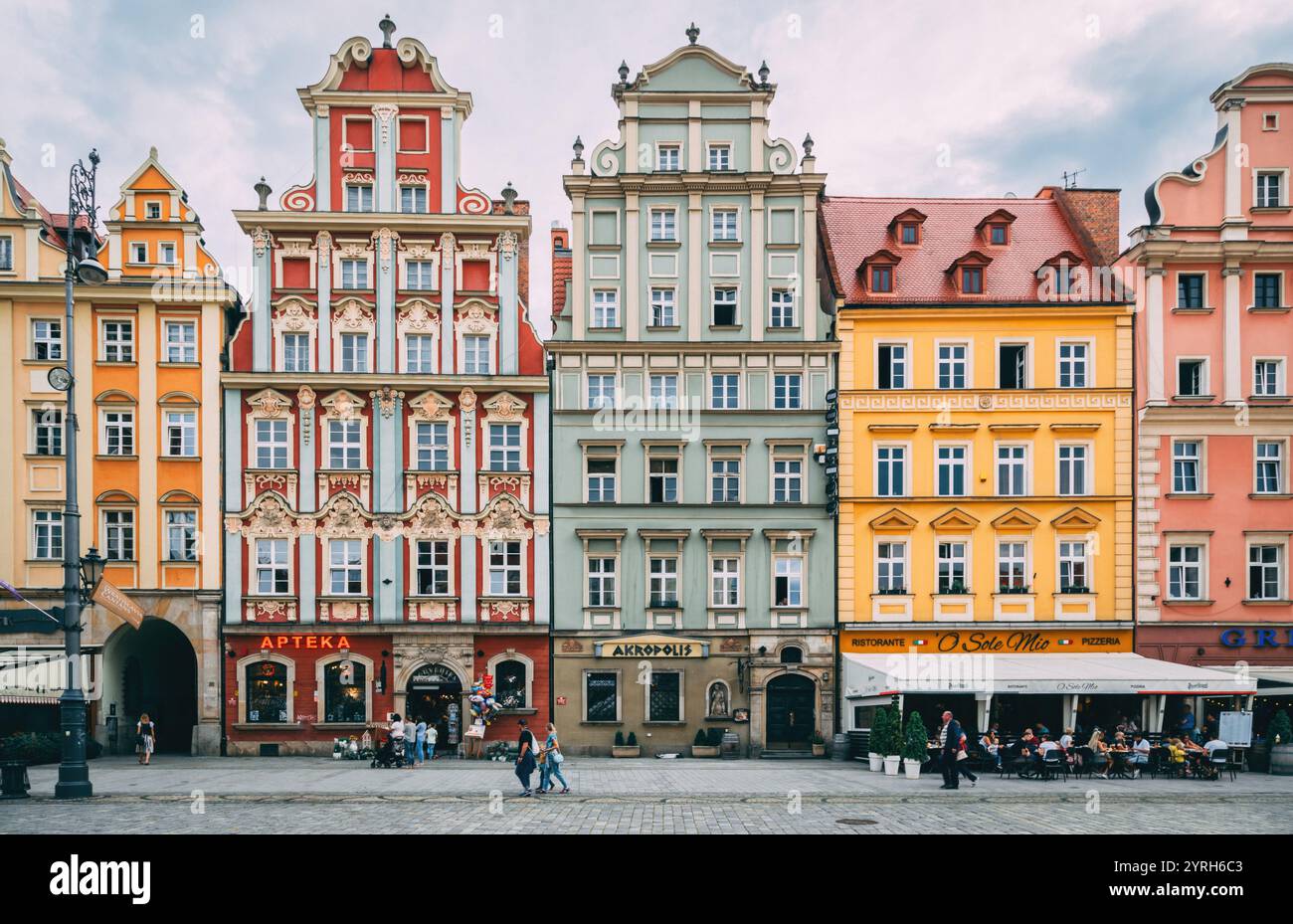 Touristen und Einheimische spazieren und genießen die farbenfrohen, historischen Gebäude entlang rynek glowny, dem Hauptmarkt in breslau, polen Stockfoto