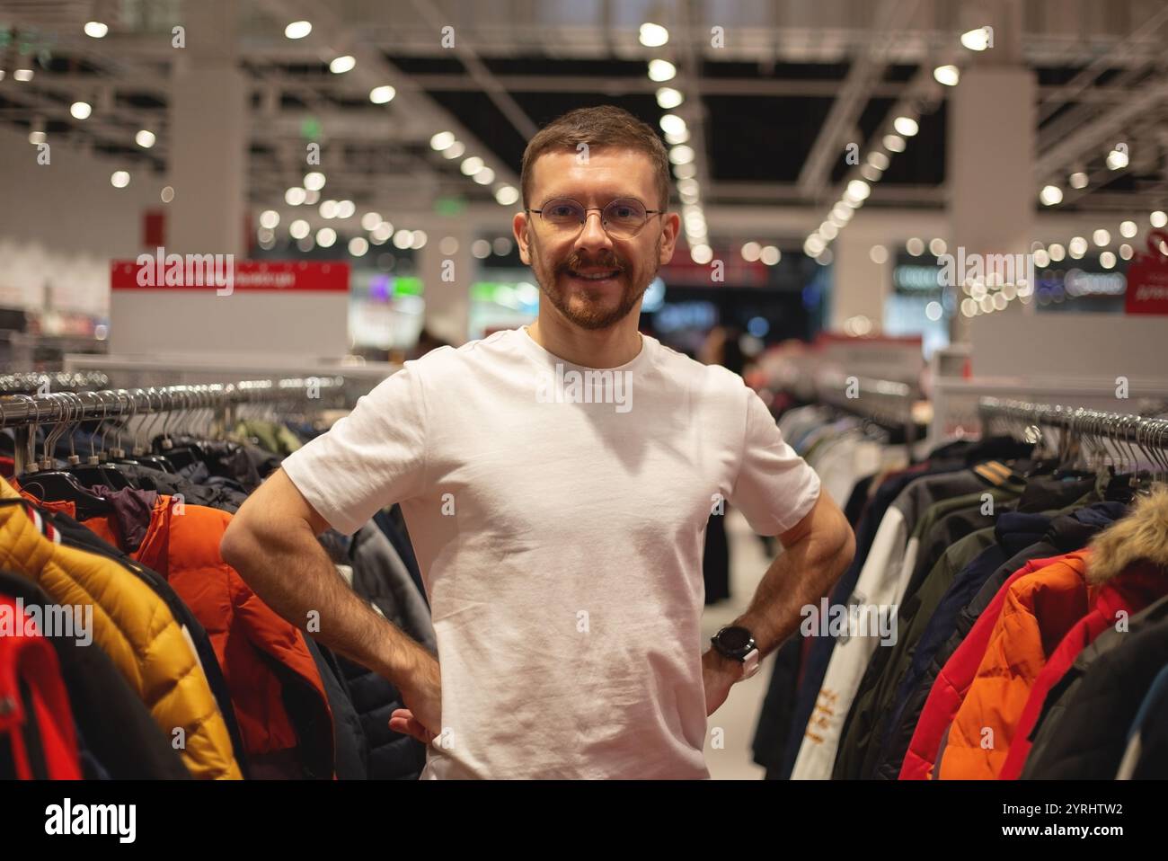 Ein Mann schaut sich Schuhe und Kleidung in einem Laden an Stockfoto