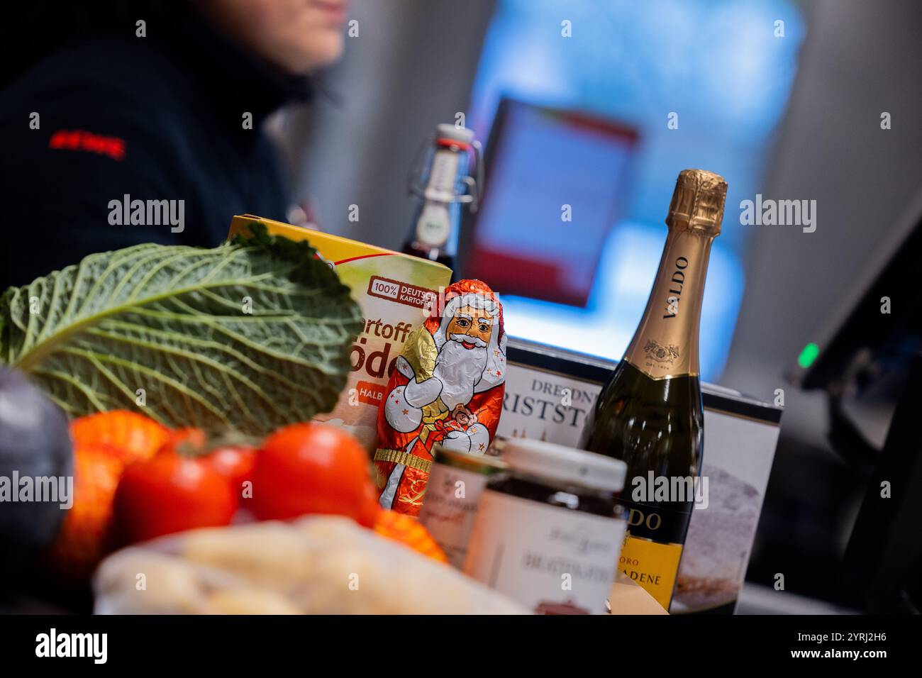 Köln, Deutschland. Dezember 2024. Verschiedene Artikel von einem Weihnachtseinkauf liegen auf einem Kassenband an einer Supermarktkasse. (Zur dpa-Umfrage: „Jede zweite Person spart Geld, wenn sie Weihnachtsessen kauft“) Credit: Rolf Vennenbernd/dpa/Alamy Live News Stockfoto