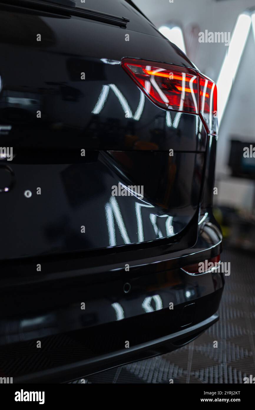Schönes schwarzes Auto hinten in der Garage. Autoservice und Autopflege Stockfoto