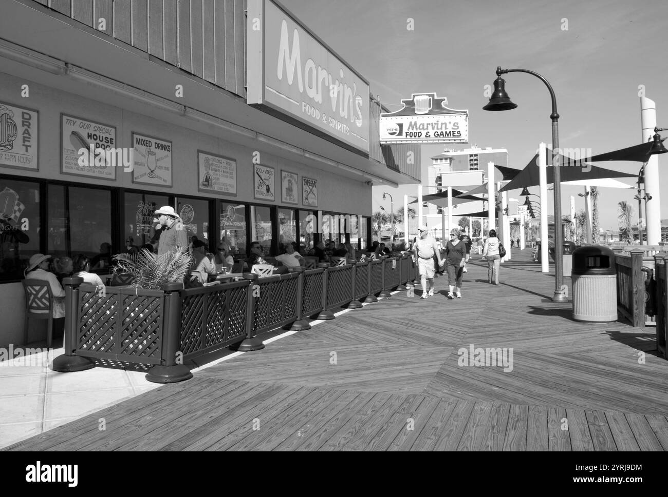 Touristen genießen eine Mahlzeit in einem belebten Straßencafé auf der Promenade in Myrtle Beach, South Carolina, USA. Stockfoto