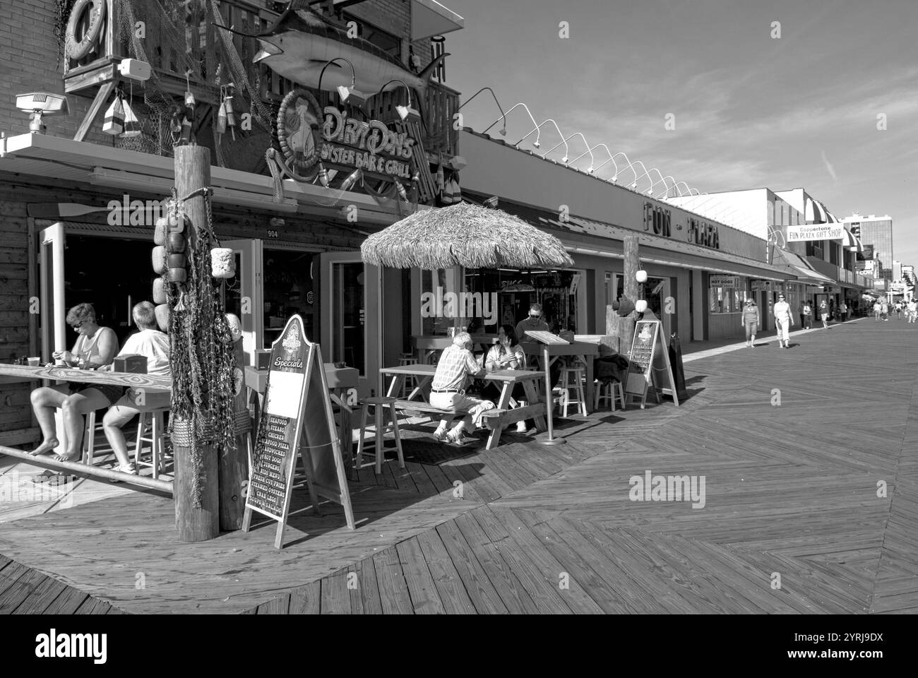 Touristen genießen eine Mahlzeit in einem Straßencafé entlang der belebten Promenade in Myrtle Beach, South Carolina, USA. Stockfoto