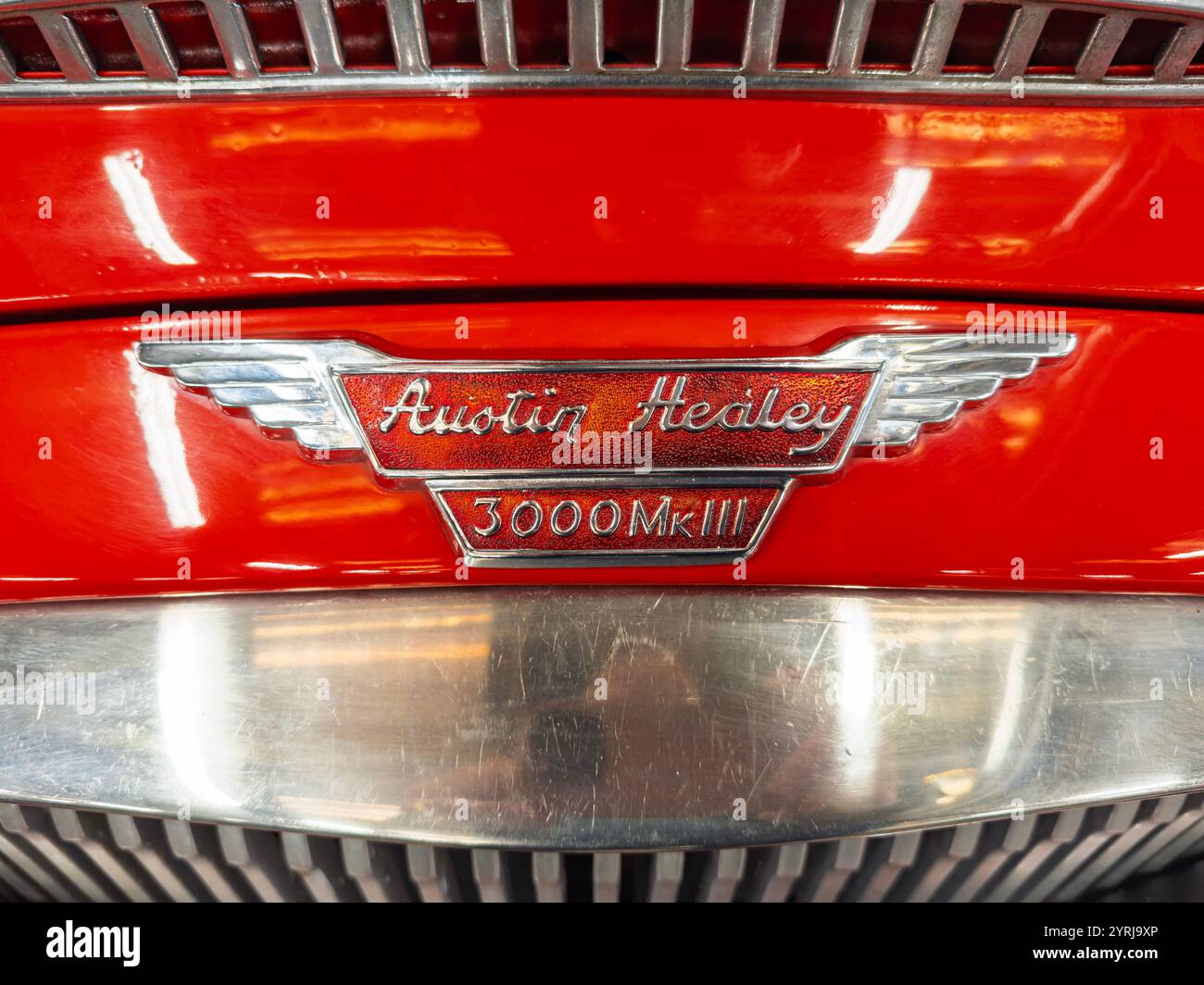 Nahaufnahme eines klassischen roten Austin Healey 3000 MK3 Sportwagens mit Emblem und verchromtem Kühlergrill - Smartphone-aufgenommenes Stockfoto